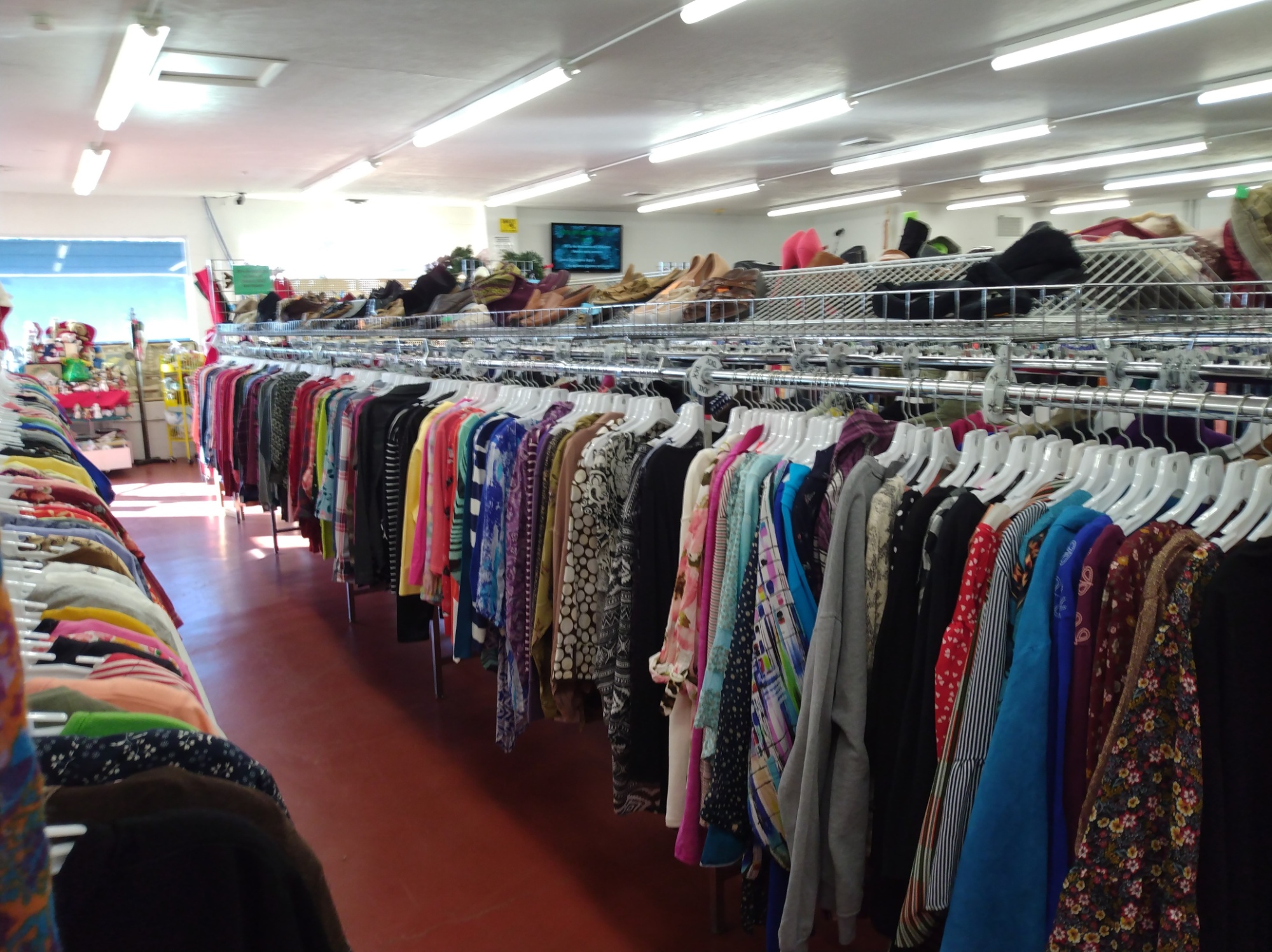 An image of a long clothing rack at a thrift store